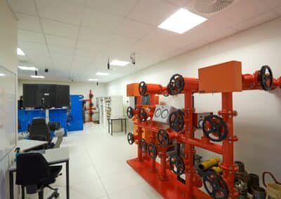 Industrielt undervisningsmiljø med rørinstallationer og skærme